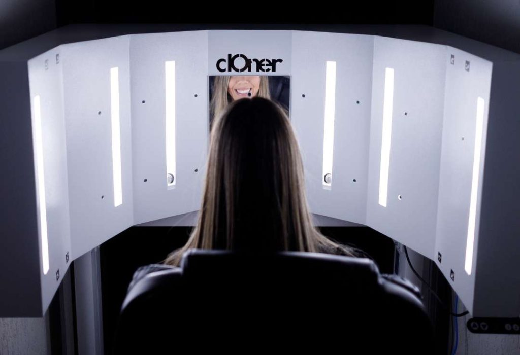 Simulação 3D para cirurgia na face - imagem de mulher em frente ao equipamento que escaneia o rosto com alta fidedignidade.